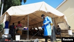 کارکنان صحی در حال میکروب‌زدایی و ضدعفونی کردن مناطق آلوده به کولرا در افغانستان