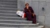 Garryja aýal döwlet binasynyň öňünde otyr. Aşgabat (Illýustrasiýa suraty) 