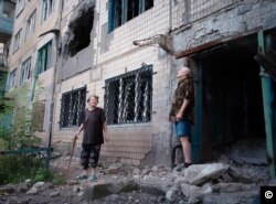 Жителі Авдіївки Ліля та Льоня дивляться в небо у той час, коли над їхніми головами пролітає снаряд