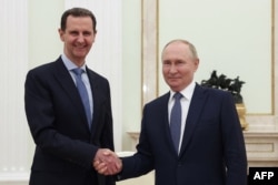 Wladimir Putin (sagda) Kremlde geçiren duşuşygynda, Siriýanyň prezidenti Başar al-Asad bilen el gysyşýar. Moskwa, 2024-nji ýylyň 24-nji iýuly