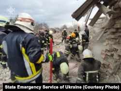 Рятувальники розгрібають завали двох повністю зруйнованих російською ракетою приватних будинків у Золочівському районі. Оточуючі будівлі теж зазнали ушкоджень. Львівщина, Україна. 9 березня 2023 року