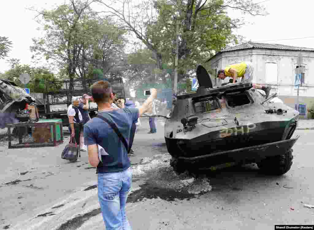 Люди оглядають знищену бронетехніку, якою, ймовірно, користувалися бойовики угруповання &laquo;ДНР&raquo;, що визнане в Україні терористичним. У боях 13 червня загинуло кілька людей, операція завершилася успіхом ЗСУ &ndash; Маріуполь було повернено під контроль української влади