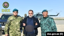 Azerbaijan -- Ruben Vardanyan is escorted by Azerbaijani security officials following his arrest.