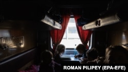 Діти-сироти, які виїхали з окупованого російською армією українського міста Пологи, чекають в евакуаційному поїзді перед виїздом на захід України, на залізничному вокзалі в Запоріжжі, 26 березня 2022 року