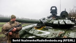 Український військовий біля пошкодженого російського танка Т-72БЗ, Донецька область, 13 квітня 2022 року