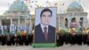 Adamlar Türkmenistanyň prezidenti Gurbanguly Berdimuhamedowyň äpet portretini göterip barýarlar.