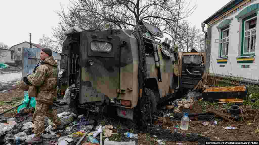 Украинский солдат рядом с брошенным российским бронетранспортером