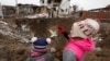 Діти дивляться на воронку, яка залишилася внаслідок російського ракетного удару в селищі міського типу Глевасі на Київщині, 26 січня 2023 року (ілюстраційна світлина)