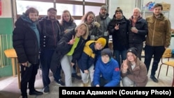 Вольга Адамовіч ў цэнтры, у салатавай майцы