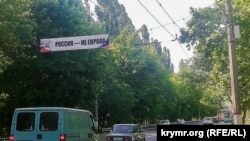 Көшедегі жол бойына ілінген жарнамада "Ресей – Еуропа емес" деп орысша жазылған. Симферополь, 2022 жыл
