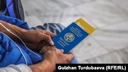 Аэропортто паспортун жана билетин кармап отурган кыргызстандык жаран. Иллюстрациялык сүрөт.