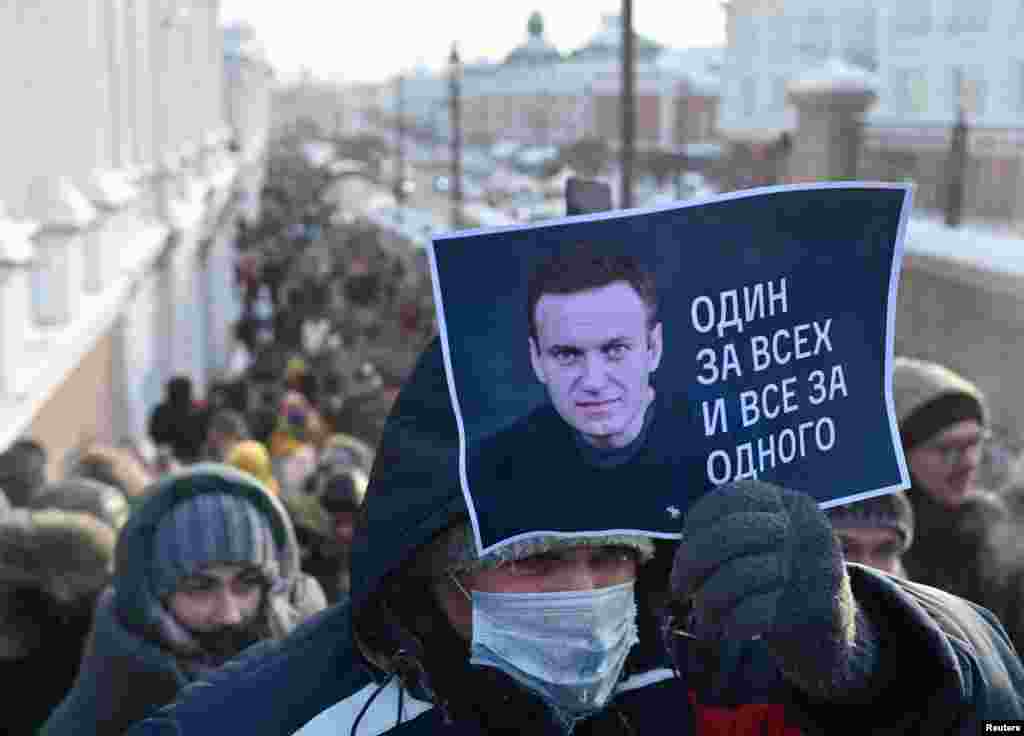 Омскда "бир киши ҳамма учун¸ ҳамма бир киши учун" деб ëзилган плакат кўтариб олган намойишчи.