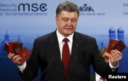 Президент України Петро Порошенко демонструє на Мюнхенській конференції з безпеки військові квитки та паспорти військовослужбовців Росії, які були здобуті в зоні бойових дій на Донбасі. Мюнхен, 7 лютого 2015 року