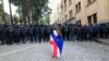 Demonstrantica ogrnuta gruzijskom i zastavom EU stoji ispred policijskog kordona na protestu opozicije u Tbilisiju (fotoarhiv)