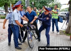 Поліція затримує чоловіка на велосипеді в центрі Алмати, де очікувався несанкціонований мітинг. 10 червня 2019 року