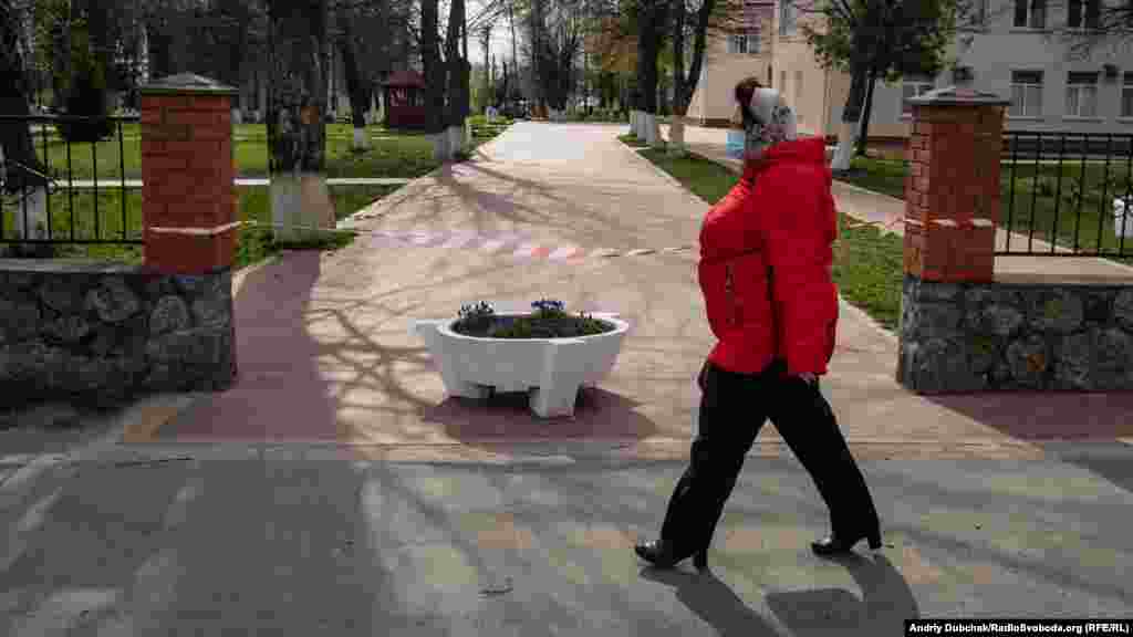 Женщина проходит мимо больницы в Калиновке. Доступ в медицинское учреждение ограничен. В Калиновке проживает около 20 тысяч жителей. Улицы в основном пусты, полицейские патрулируют город и из громкоговорителей призывают местных не выходить из дома 