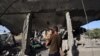 Palestinac drži dijete u naručju i posmatra ono što je ostalo od kuće koja je bila meta izraelskog napada na izbjeglički kamp Nuseiratu u centralnom Pojasu Gaze, 24. maja 2025.