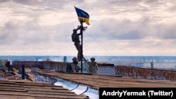 Украинанын Куралдуу күчтөрү бошоткон айылга туу илип жаткан учуру. 4-сентябрь, 2022-жыл.