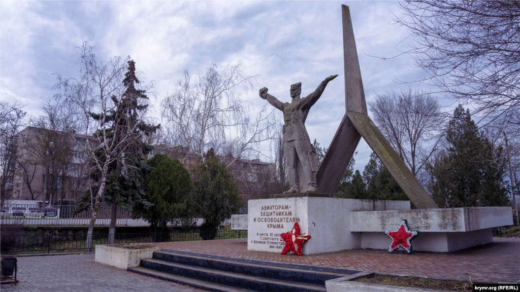 Пам'ятник загиблим під час звільнення Джанкоя від нацистських окупантів був збудований в 1965 році. Зліва за ним, через Московське шосе, яке веде до адміністративного кордону між анексованим Кримом і Херсонською областю, видніється багатоповерхівка колишнього авіагарнізону. Там за радянських часів та в перші роки незалежної України дислокувався полк ВТА – військово-транспортної авіації, штаб з'єднання якого знаходився в Мелітополі. Нині в Джанкої літають російські вертолітники