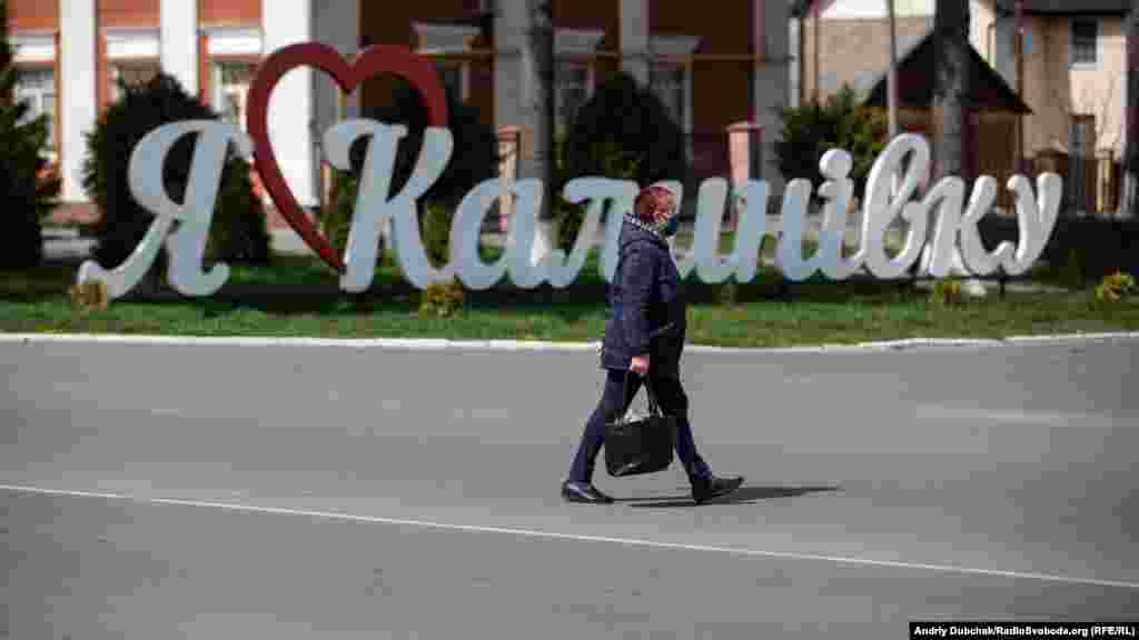 Женщина проходит мимо знака с надписью «Я люблю Калиновку» 