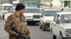 Вооруженный офицер специального подразделения узбекской полиции стоит на окраине Ташкента.