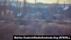 The permanent emplacements of militants of the Russian hybrid forces in the middle of the settlement and the flag of the so-called “Novorossiia” over them