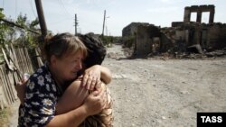 Two women hug each other amid ruins in the South Ossetian capital of Tskhinvali, which was devastated by the brief Georgian-Russian conflict in 2008. 