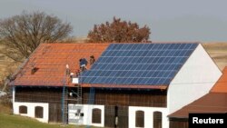 Германија - Работници инсталираат 320 квадратни метри соларни панели на покрив на штала.