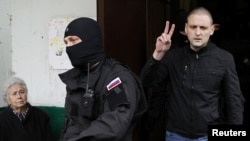 Сергія Удальцова (п) ведуть із дому на допит, 17 жовтня 2012 року