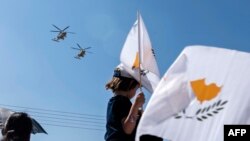Тестиер бала Кипрдин желегин булгалоодо. Никосия шаары. 2019-жылдын 1-октябры.