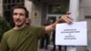 Снимката е илюстративна. На нея протестиращ държи плакат с надпис "Комисия за противодействие на борбата с корупцията" пред сградата на Комисията за противодействие на корупцията в София, 9 юли 2025 г.
