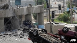 Overturned cars lie on a collapsed bridge in the capital, Santiago, after the 8.8-magnitude earthquake on February 27.