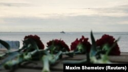 Квіти на пірсі поряд із місцем падіння Ту-154, на задньому плані катер російського МНС. Сочі, 26 грудня 2016 року