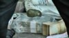 Деньги и граната, конфискованные у подозреваемого в совершении разбойного нападения, 3 мая 2018 г.