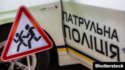 Машина патрульной полиции и дорожный знак «Осторожно, дети»